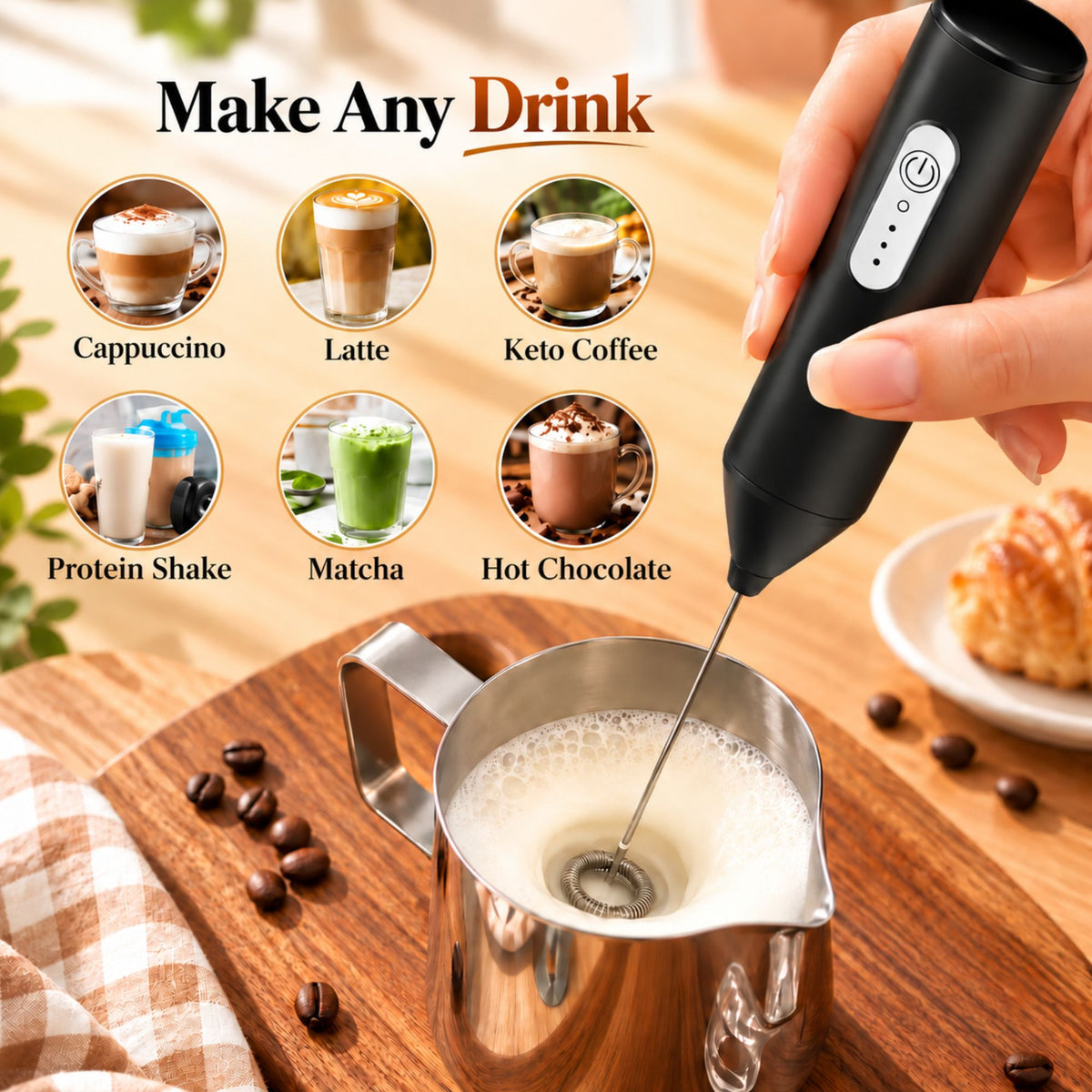 A hand holds a black handheld electric milk frother over a stainless steel pitcher filled with foamy milk on a wooden surface. The image includes the text 'Make Any Drink' and six circular example images showing cappuccino, latte, keto coffee, protein shake, matcha, and hot chocolate.